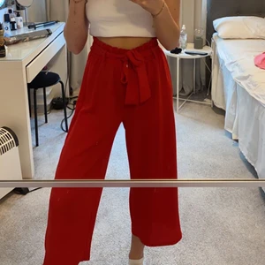 Röda byxor - Säljer ett par röda supersköna byxor med resår och ett knytband i midjan som man också kan ta bort om man vill det! Jättefint skick då de inte kommit till så stor användning❤️ perfekta på sommaren då de är ganska tunna och lite kortare i benen☺️