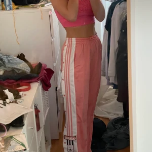 Rosa adidas mjukisbyxor - Bra skick med knappar på sidorna. Snören i midjan. Storlek S. Långa på mig som är 172 för referens. Nypris 730 kr