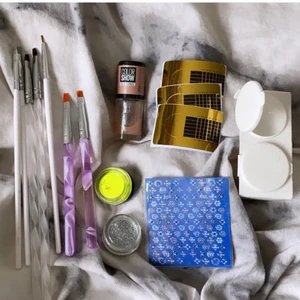 nagelsaker - säljer lite gelenaglar saker. du får med : 7 penslar som är använda, skimmer-nagellack , neongult pigment, 2 glitter, nagelklistemärken, 3 mallar, och en burk där du kan ha gele eller glitter i! i nagellacket är det ca halva kvar och penslarna är lite använda!