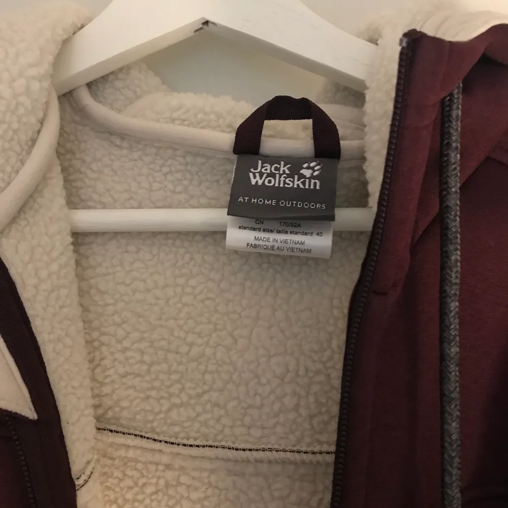 Purple long jacket from Jack Wolfskin in perfect condition, barely worn. Beautiful purple color and white warm interior lining. Great for colder weather. Brand tag on the front under the pocket and a paw tag on the sleeve. Retails for over 1000 SEK.. Jackor.