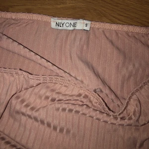 Body - Beige, ribbad off shoulder body från Nelly, storlek S. Du stänger bodyn med knappar! Använd en gång🤍 