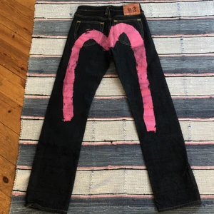 Evisu jeans - LOT:0050 Size:24                                                                     Gick för 200$ på grailed.                                                          Öka bud med minst 20kr eller köp direkt 1200kr                                    Midjan: 65cm innerben: 74cm.                                       Saknar en liten knapp på sista bilden men inget som syns direkt.                                                                         På tredje bilden ser ni hur dem sitter på en tjej som har 73cm i midjemått