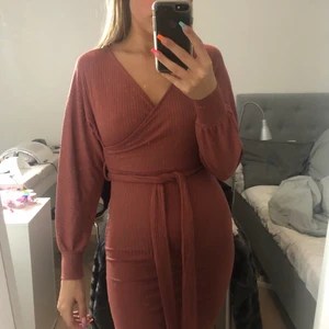 Brunröd klänning S - Prislapp kvar. Klänningen är använd endast på bild. Sitter fint på kroppen och tar slut på mitten av låret på mig som är 168cm lång. Storlek S men med stretchigt material som kan passa flera storlekar större