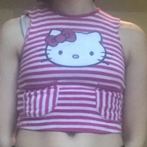 Söt hello kitty topp!! - Jätte gullig vit/rosa randig hello kitty topp. Köpt på second hand men i bra skick och inga skador. När jag köpte den var den långärmad så jag klippte av till ett linne men det är inget man stör sig på. kan mötas i sthlm eller posta!