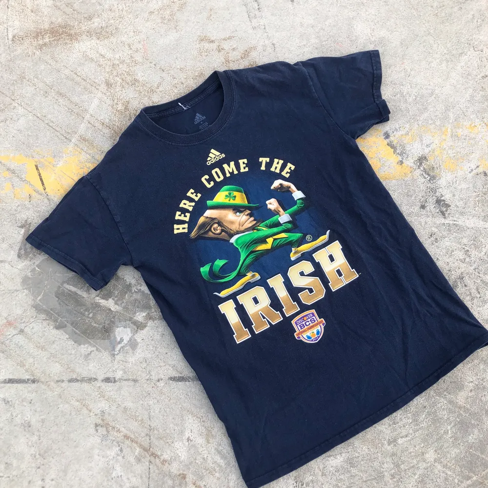 Sjukt snygg college t-shirt producerad av Adidas åt Notre dame, Indiana och deras Amerikanska fotbollslag Fighting Irish från National Championship 2013. Tröjan är S men passar något mindre. Sjukt snyggt tryck. Tröjan är även i grymt skick och inga direkta defekter. Tveka inte att höra av dig om du undrar något! 🌱✌🏻🏈. T-shirts.