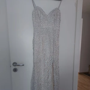 Fest klänning storlek 36-38 - En lång fest klänning använd en gång  färg silver med ljus beige tyg under. Öppning på sidan