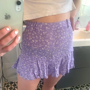 Kjol zara - Jättefin lila blommig kjol från zara! Kjolen har shorts under och ett band runt om som man kan ta av! Jätteskön och snygg!❣️