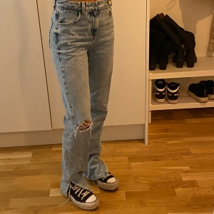 Zara jeans stl 32 - Jeans från Zara med slits, ett hål på knät och lite annorlunda knäppning💙 Medel hög midja och i väldigt fint skick🙌🏼Jag är 160 och har platåskor på mig och då går jeansen precis ner till marken💫 Det är storlek 32 på de men har 34 i vanliga fall. Kan stickas på posten och då tillkommer frakt🌀