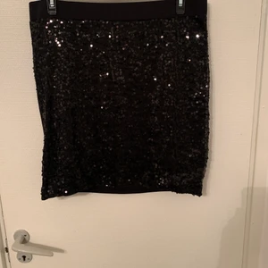 Kjol med paljetter - Tight kjol med paljetter på framsidan och bak vanligt strech tyg. St: 44-46. Aldrig använd