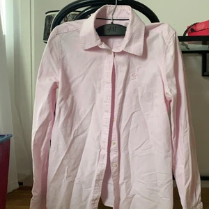 Rosa gullig Skjorta - En jättefin skjorta från Ginatricot i strl 38. Skulle dock säga att den är kanske 36 (s). Säljer pga för liten då den inte  går att knäppa vid bysten. Fattas en knapp i andra hålet. Annars helt ny och oanvänd!  Köparen står för frakt🥰, bara att skriva om du har någon fråga! 