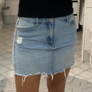 Jeanskjol  - Lågmidjad jeanskjol. Köparen står för frakten