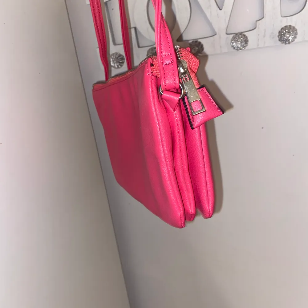 Super cool och snygg  rosa handväska med tre större fack och 2 mindre fack. passar perfekt till sommaren. säljer för ca 30  kr. Pris kan diskuteras. Väskor.