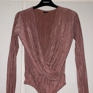 Sting body - String body i glittrigt tyg. Passar både till fest och vardags. Går jätte bra att använda en säkerhetsnål om man vill få en mindre urringning. Använder inte längre men är i fint skick! 