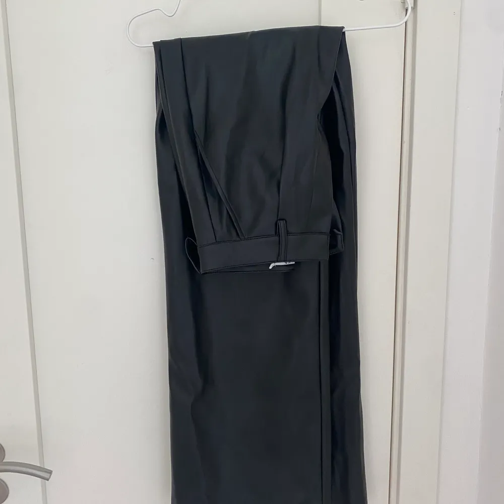 Svarta ”skinn” kostymbyxor, de har en oversized passform och långa i benen, jag är 172 cm. Storlek 34/36. Från NAKD, nypris 579kr. Bra skick!. Jeans & Byxor.