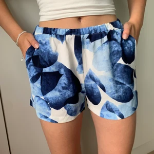 Vit och blåa shorts  - Ett par fladdriga, sommriga shorts med ett mönster av blommor! 