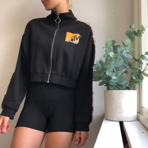 Kofta med dragkedja  - En snygg kofta med dragkedja, kort modell med tryck av MTV.