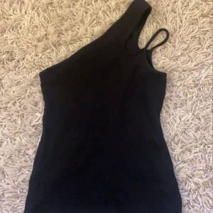 Linne med snedskuren Axel  - Ett linne ifrån nelly som är andvänt 2-3 gånger endast! Snedskuren vid axeln och jättefint skick! I storlek xs. Kontakta mig privat vid frågor<3 