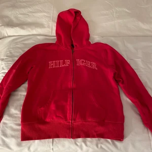 Tommy Hilfiger tjocktröja - Säljer denna rosa/magenta färgade tjocktröjan från Tommy Hilfiger. Köpt för flera år sedan i usa, den finns därför inte längre kvar i deras sortiment. Tröjan är i barn storlek L men passar fortfarande mig som är vuxen S. Köparen står för frakt. Högsta bud: 180kr