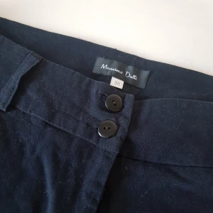 Chinos/byxor strl 38 Massimo Dutti - Marinblåa fina byxor från Massimo Dutti. 100 % viscose. Mjuka och sköna, men passar bra som snyggare byxor.  Innerbenslängd ca 82 cm. Midja mätt rakt över ca 40 cm. 