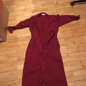 Byxdress omsydd till klänning med slit - En gammal byxdress som är omsydd till en klänning med knappar helsvarta och slits i bak. 