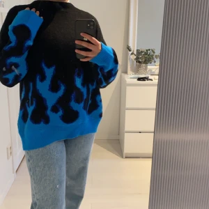 svart mjuk tröja mee blåa eld flammor - Denna tröja är helt oanvänd, den varken sticks eller är nopprig. Dessvärre kommer den inte till användning för min del❣️Den är i Storlek L men i oversize blir det i storlek S skulle jag säga. BUDNING‼️ + fraktpris 66kr spårbart