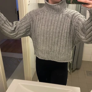 Stickadtröja - Stickad tröja från HM i en fin grå färg. Den är sparsamt använd. Härlig ståkrage som är skön nu på våren. Storleken är L men den är mer som en M