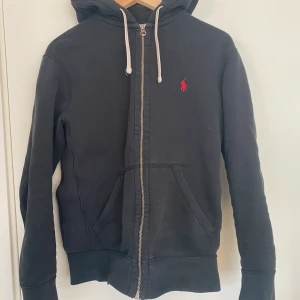 Ralph Lauren hoodie, dragkedja - En svart Ralph lauren hoddie med dragkedja och rött märke, storlek S, condition 8/10