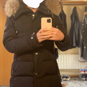 Vinterjacka Hollies - Snygg vinterjacka med pälsluva från Hollies. Som ny, en liten tygflärp saknas på en av dragkedjorna till en ficka). Stolek 38 och passar mig som är 166 cm lång. Köpt vintern 20/21 på Johnells för 4000kr