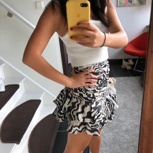 drapperad zebra kjol - Drapperad kjol med volang i zebramönster från HM. Den är lite högre i midjan och snedskuren nertill. Supersnygg även nu till hösten med en stickad tröja till. Har aldrig kommit till användning och säljs därför i bra skick! Stl: 32. Pris: 200kr, frakt tillkommer.