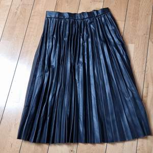 Plisserad kjol i fake leather från linser. Superfint höstplagg till blus eller stickad tröja. 