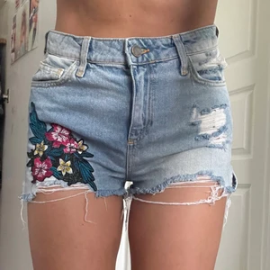 Jeans shorts Zara i 38  - Säljer dessa jeans shorts med blommor både fram och i bak från Zara i storlek 38 då jag ej använder längre. Dessutom är dom lite förstora i midjan. Frakt tillkommer 💛