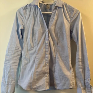 Ljusblå skjorta strl 34 - Ljusblå skjorta, strl 34. Hämtas i Bromma eller skickas, köparen står då för frakt 