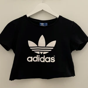 Adidas croppad T-shirt - Köpt i Adidas Store i Stockholm, bra skick. Tröjan är klippt till en crop top, på mig går den ca 7 cm under bysten.