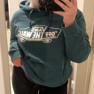 Mörkgrön vans tröja  - En mörkgrön vans tröja med luva, tryck på brösten och ficka på magen. Fint skick, säljs pågrund av att jag inte använder den. Men tyvärr så har jag spilt lite blekning på ena armen, vid handen. Storlek L. 