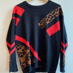 Svart tröja med detaljer i rött och leopard. Från topshop, storlek 36. 