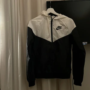 Nike vindjacka - Vit och svart vindjacka från Nike i st XS, den är använd typ 2 gånger annars är det ny och fräsch.