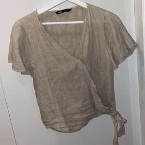 Zara blus - Beige topp/blus från Zara som knyts i midjan och som är vid i armen med en liten söm! Säljs då den är ganska stor i storlekn. 🤍