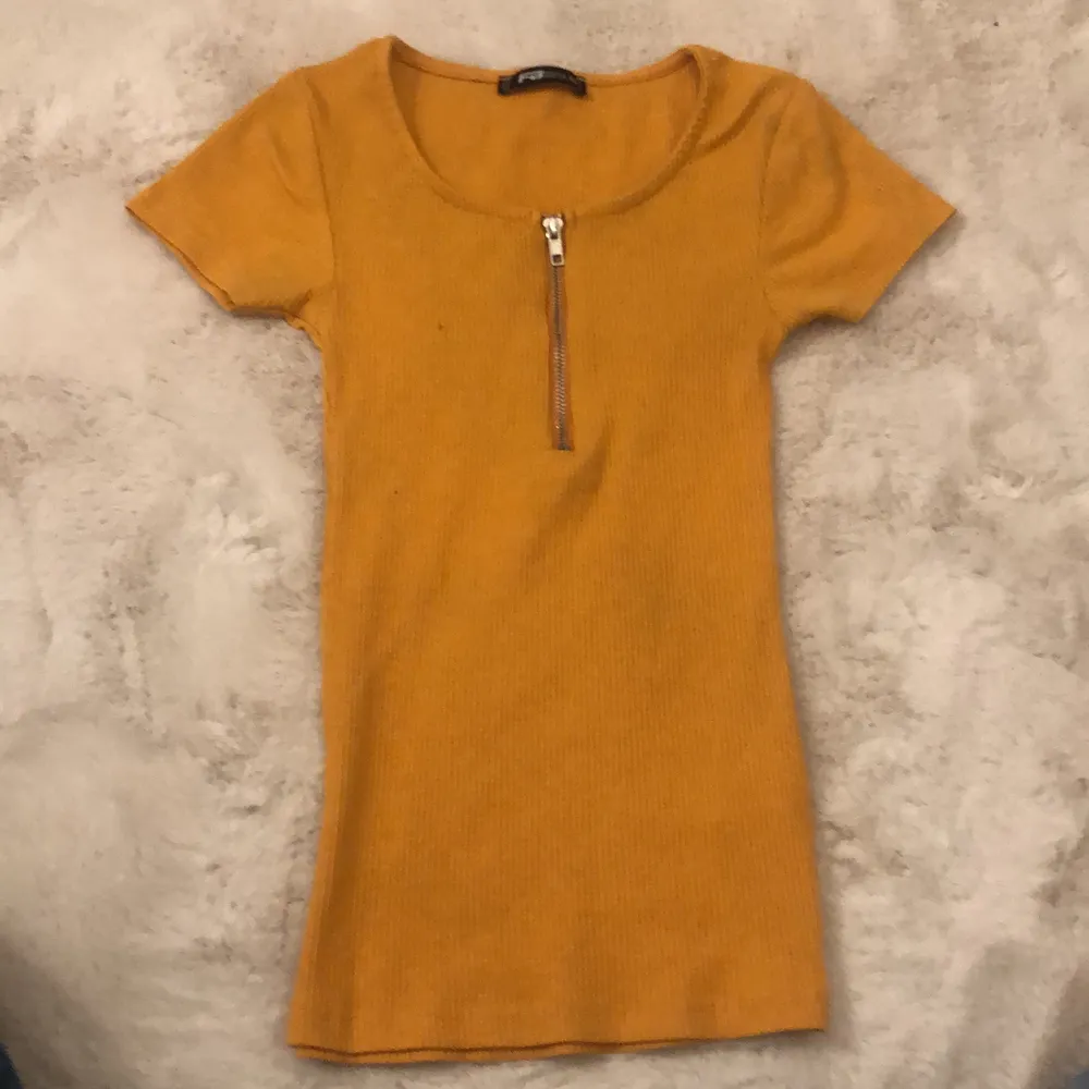 Orange lite tajtare t-shirt från NEW yourker. Även en liten dragkedja som går liten bit ner. Nästan aldrig använt (Bara testad).. T-shirts.