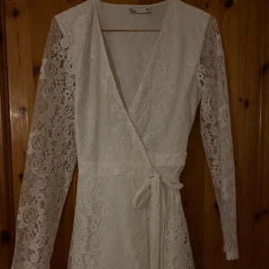 Vit spetsklänning  - Vit spetsklänning ifrån NLY trend, använd 1 gång så inga tecken på slitage, säljs pga att de inte används, perfekt till student/examen!!💓 De är knyt i midjan vilket gör den justerbar och passar både större och mindre storlekar☺️