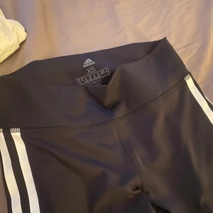 Adidas träningstights - Svarta adidas träningstights med vita ränder från adidas. Använda typ 2 gånger väldigt fint skick. 