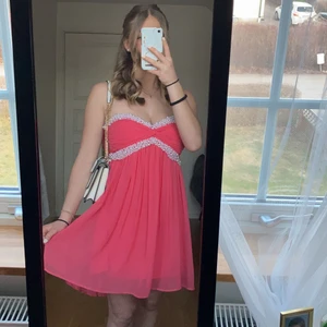 Rosa balklänning - Jättefin kort rosa balklänning!💞 söta pärlsetaljer där fram. Stängs med dragkedja och hake på sidan. 