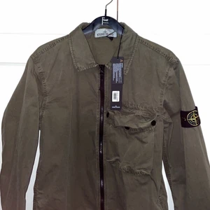 Stone Island overshirt - Helt ny med tags och box finns kvar (aldrig använd, endast provad). Den är i storlek S och nypriset är 3599kr på Johnells.