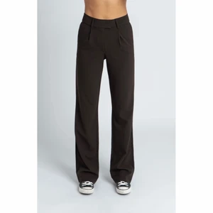 Byxor från LXAthelabel - Aldrig använda, helt nya kostymbyxor från LXAthelabel, Linn Ahlborgs märke. De är i en mörkbrun färg i storlek M. Väldigt långa i benen. Nypris 699kr.