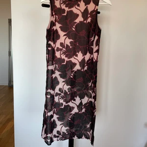 Blommig topp - Romantisk topp i blommigt tyg! En undertopp som är kroppad och ett tunt tyg över som räcker ner till knäna (på mig, 162 cm). Storlek XS men skulle säga att den passar S också. Frakt tillkommer!