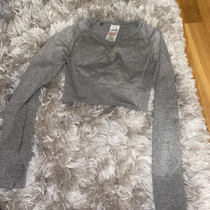 Gymshark crop top - Crop top den gymshark, använd ett fåtal gånger. Grå med babyrosa detaljer.