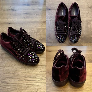 Prada sneakers stl 40 - Vinröda sneakers i sammet med strass från Prada. Inköpta i december 2017 på MyTheresa (kvitto finns). Nypris 650 Euro. Använda endast en gång - i mycket gott skick! Stl 39,5 men passar mig som har stl 40.