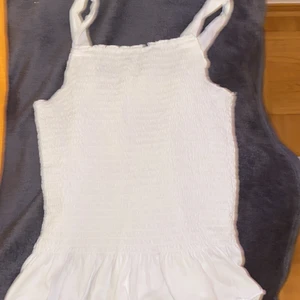 Ribbat Linne - Säljer denna jättefina sorts ribbade linne med mini volang nertill som är lite trendiga nu från ZARA. Storlek 11-12 barn men den är super stretchig och sätter sig på kroppen lite efter din storlek ca XS-S skulle jag säga hör ev er privat för frågor/bud. (Frakt tillkommer efter packetering och vägning)