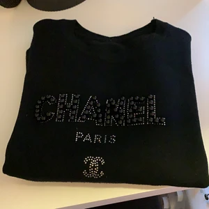Skitsör men Ej äkta! Chanel tröja  - Skitsöt tröja med ”Chanel Paris CC” på framsidan i pärlor och rinestones. Kommer inte ihåg vart den köptes, men är definitivt ej äkta. Om du ska mötas så läggs det till 38kr på priset. Har fixat nopprorna på den 🥰 färgen är som på första bilden ☺️