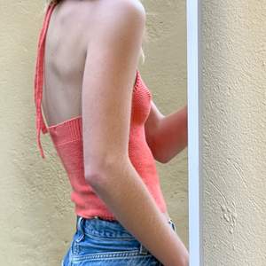 Knitted top with tieback neck in a peachy colour 