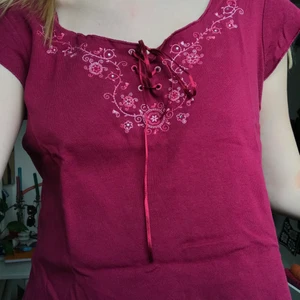 Hallonröd top  - En hallonröd top med fina broderi-detaljer. Står storlek 42 på lappen men jag har storlek s som referens:) 